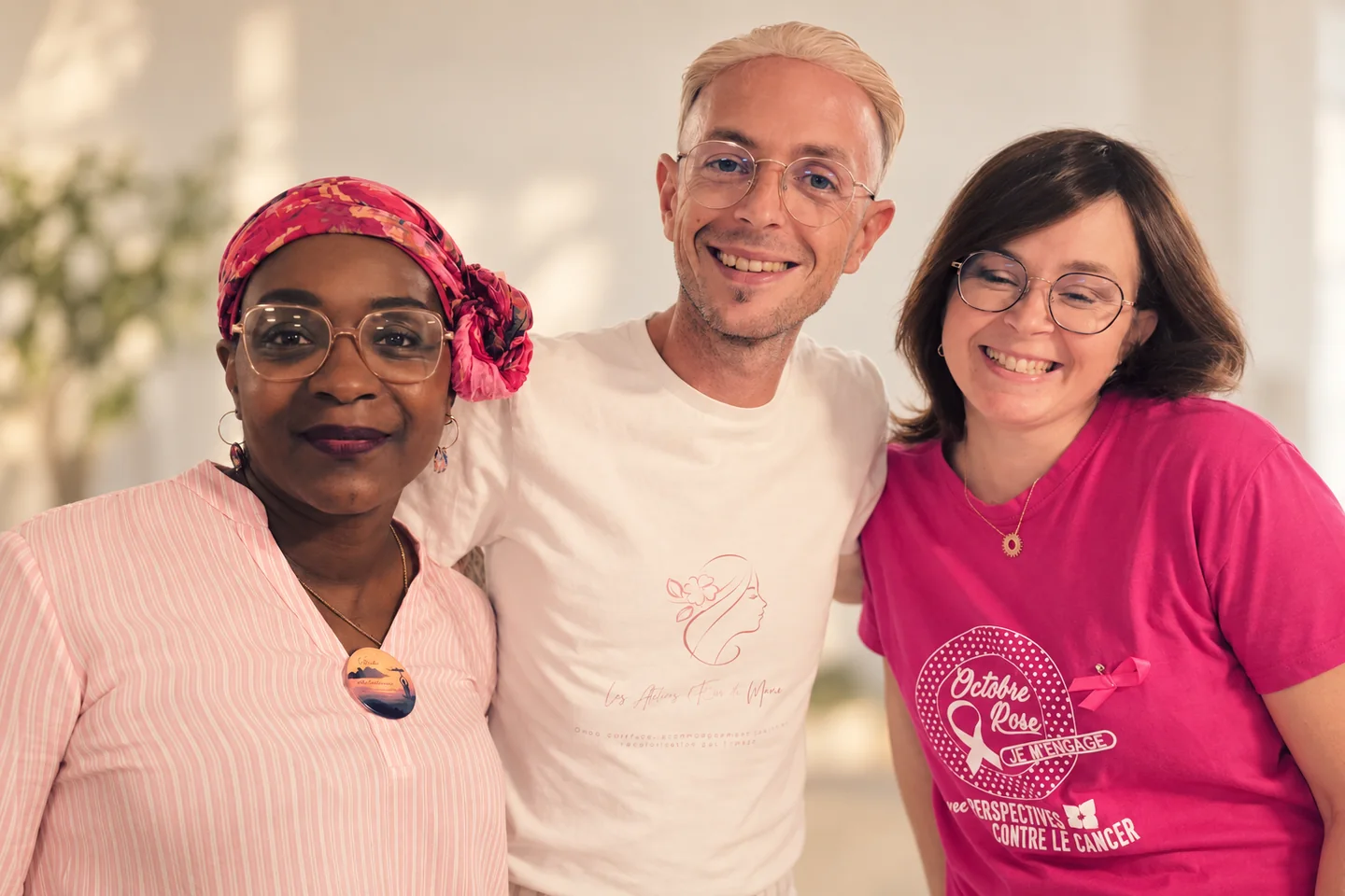 Portrait de trois personnes souriantes, dont une portant un turban coloré.